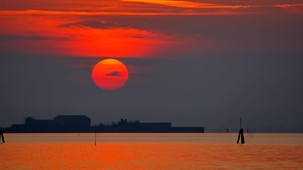 Venice Hotel for Sale — Sale & Leaseback 3 Venice: sunset over the lagoon seen from the Lido, with the red sun on the water