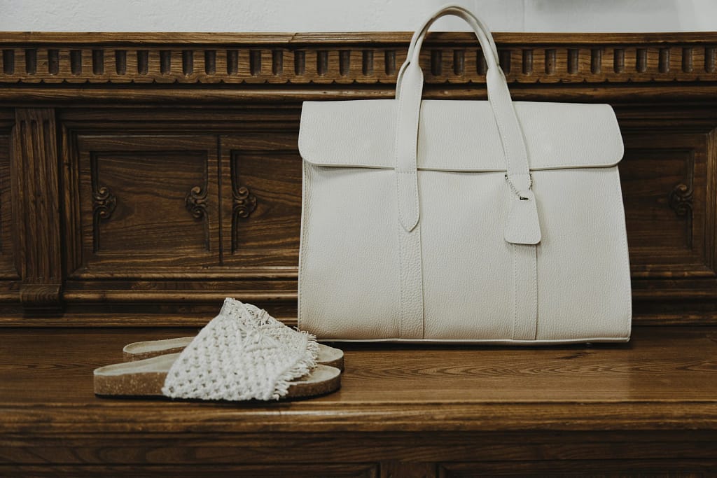 Moda di lusso per destinazione 23 Borsa bianca su una panca in legno