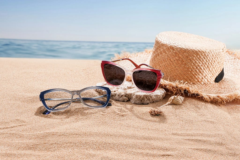Moda di lusso per destinazione 13 Cappello di paglia e occhiali sulla sabbia