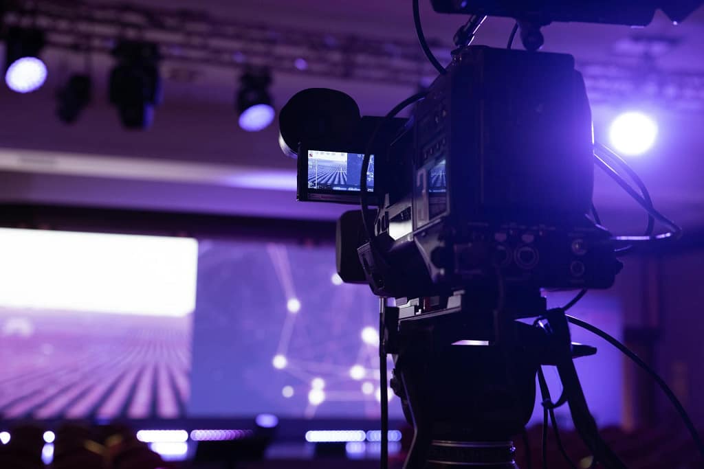 Eventi privati in villa 10 Eventi privati in villa: telecamera professionale davanti al palco illuminato (foto illustrativa)