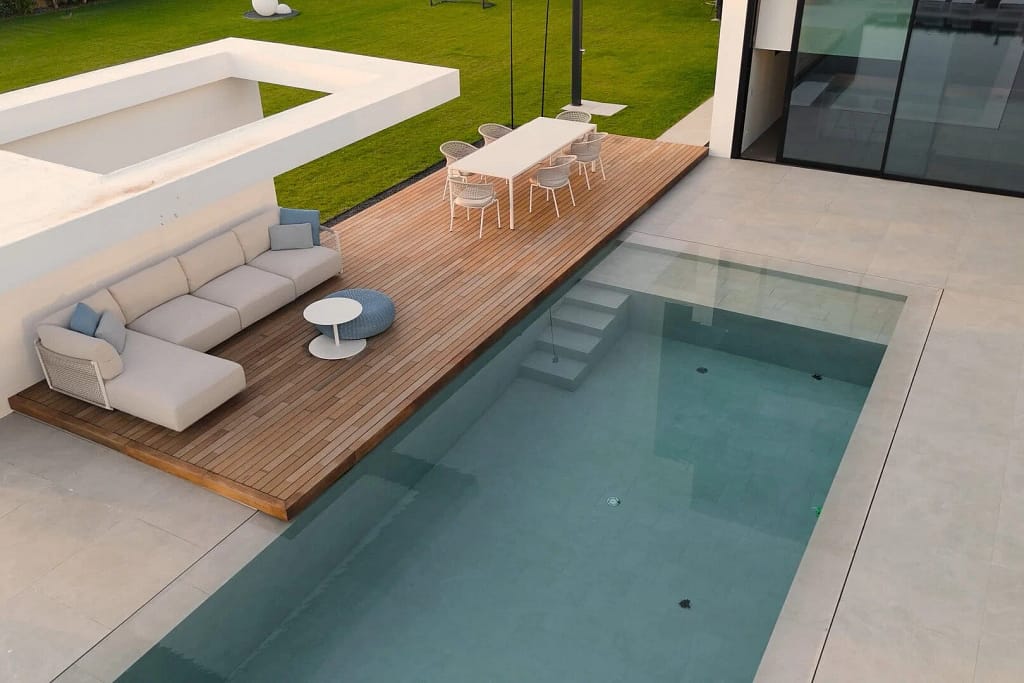 Gres porcellanato in grandi lastre 1 Gres porcellanato: piscina con deck in legno e lettini