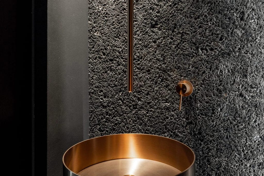 Luxury bathroom: copper basin on lava stone