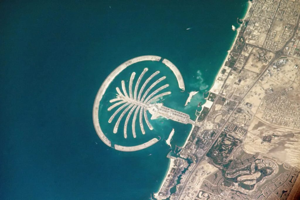Luxury villas in Dubai: Palm Jumeirah seen from space, with the trunk, the fronds and the crescent