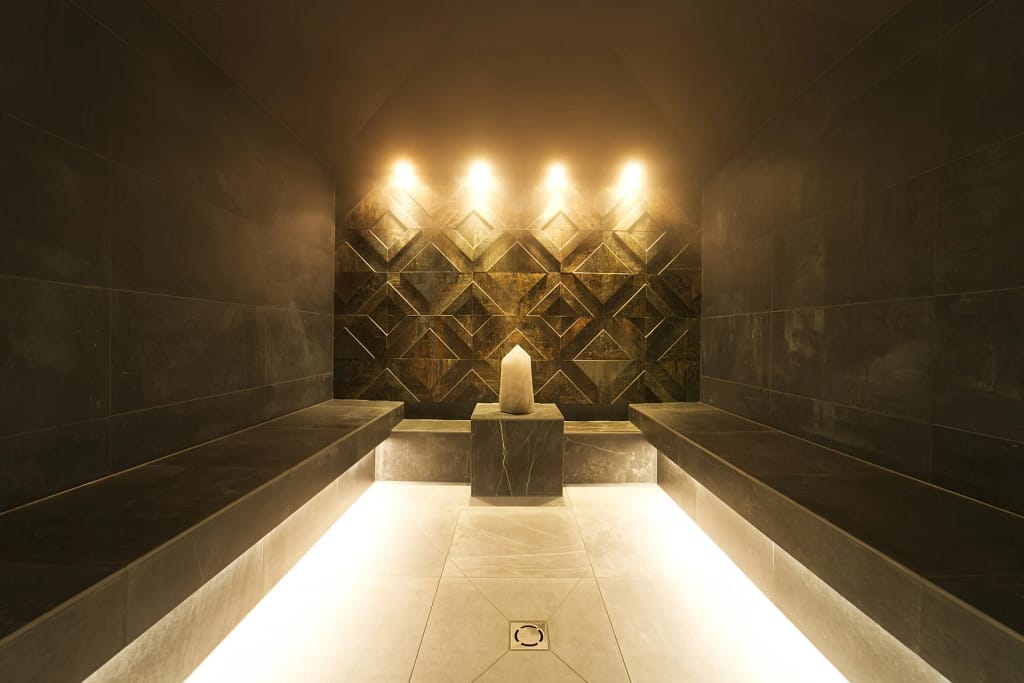 Spa in casa: sauna, vapore, acqua e riposo 3 Spa in casa: bagno turco in pietra con luce calda e seduta (foto illustrativa)