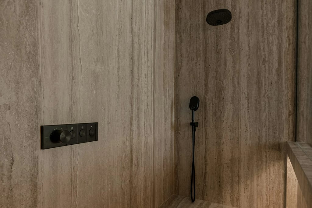 Spa in casa: sauna, vapore, acqua e riposo 7 Spa in casa: doccia emozionale in travertino con soffione a pioggia e luce radente (foto illustrativa)