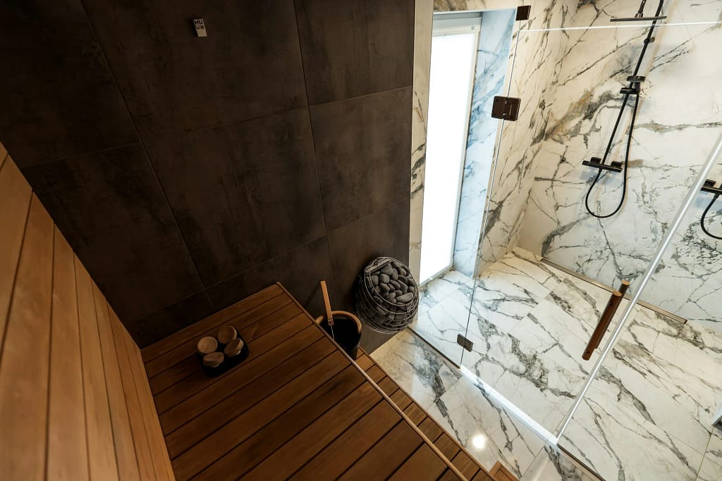 Spa in casa: sauna, vapore, acqua e riposo 21 Spa in casa: sauna in legno accanto alla doccia in marmo (foto illustrativa)