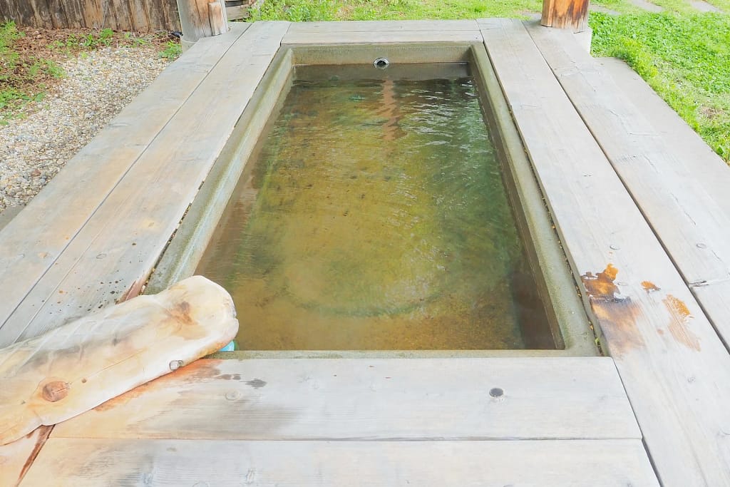 Spa in casa: sauna, vapore, acqua e riposo 23 Spa in casa: vasca Kneipp in pietra e legno nel giardino (foto illustrativa)