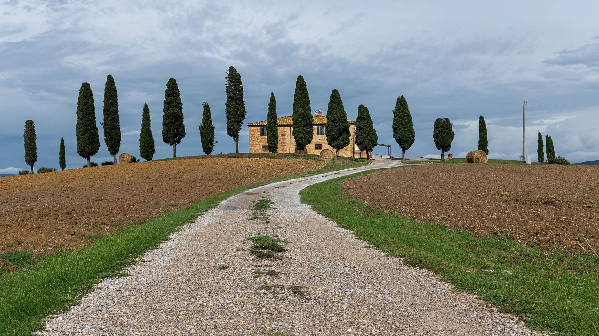 Made in Italy 23 Luxury villas in Tuscany: gravel road to a farmhouse with cypress trees in Val d'Orcia