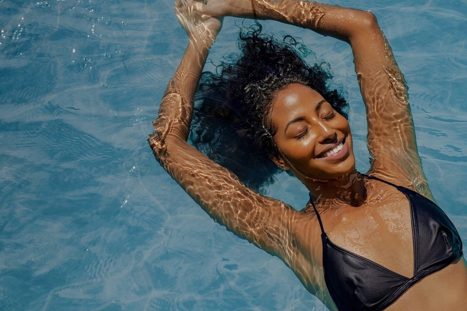 High,Angle,View,Of,Black,Woman,Relaxing,In,The,Water