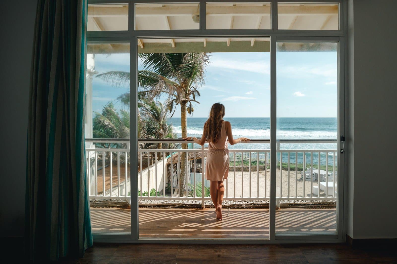 Young,Woman,Standing,On,The,Balcony,And,Looking,At,The