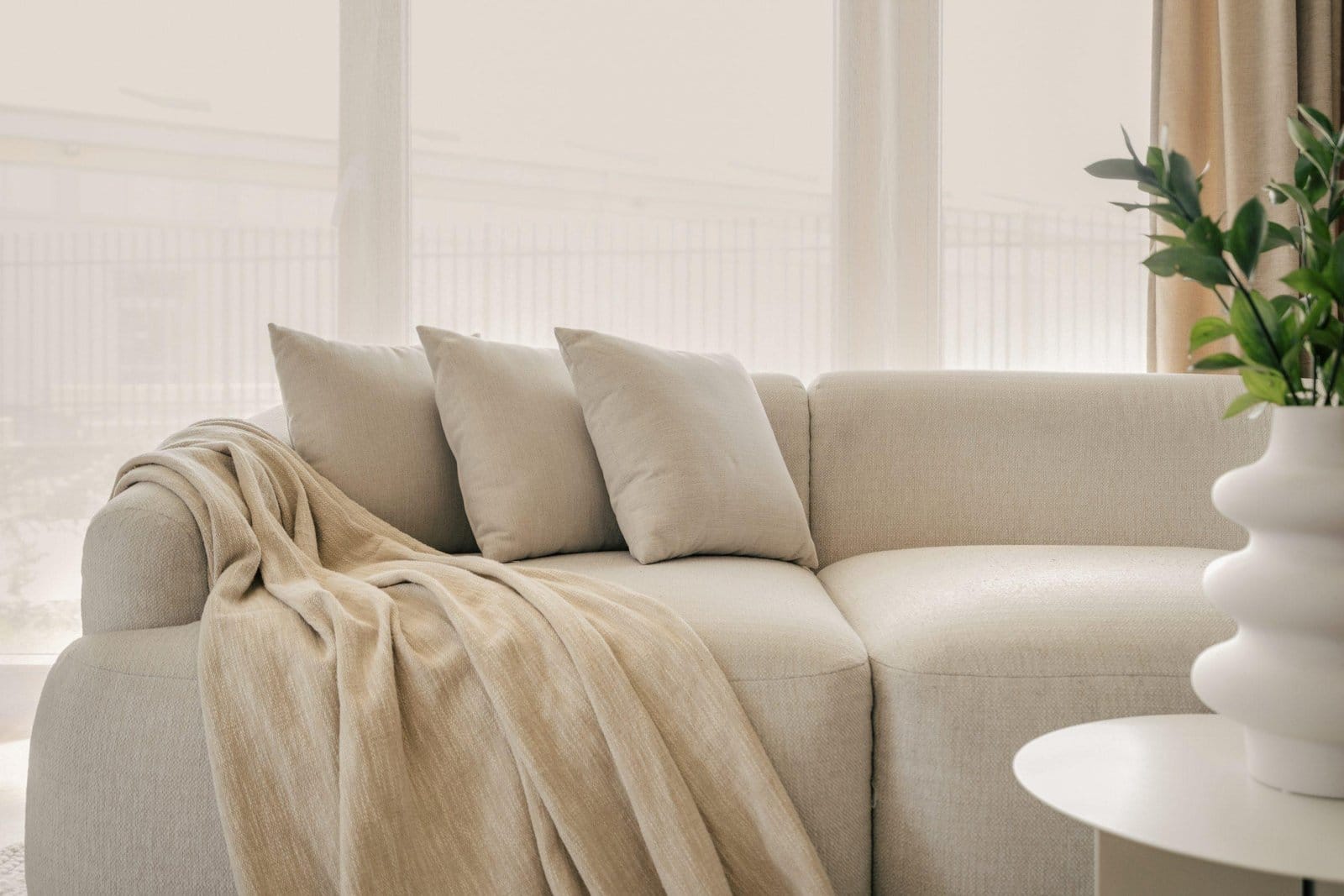 Three,Grey,Pillows,And,Blanket,On,Grey,Soft,Sofa,In