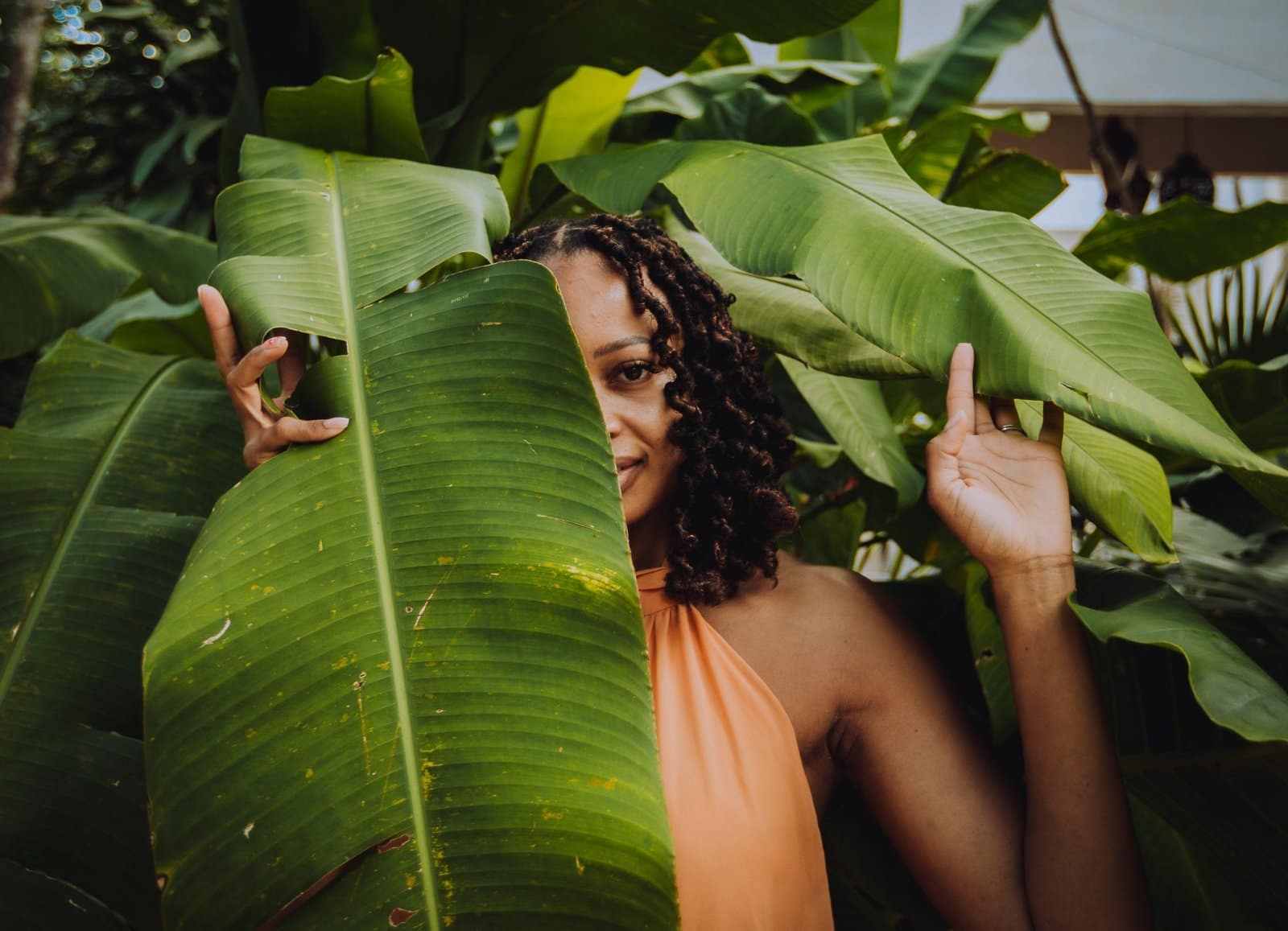 Black,American,Women,Wearing,Orange,Dress,Posing,Between,Green,Banana