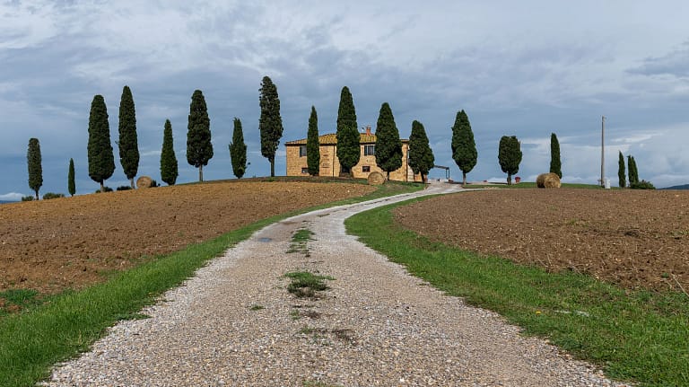 Made in Italy 23 Ville di lusso in Toscana: strada bianca verso un casale con cipressi in Val d'Orcia